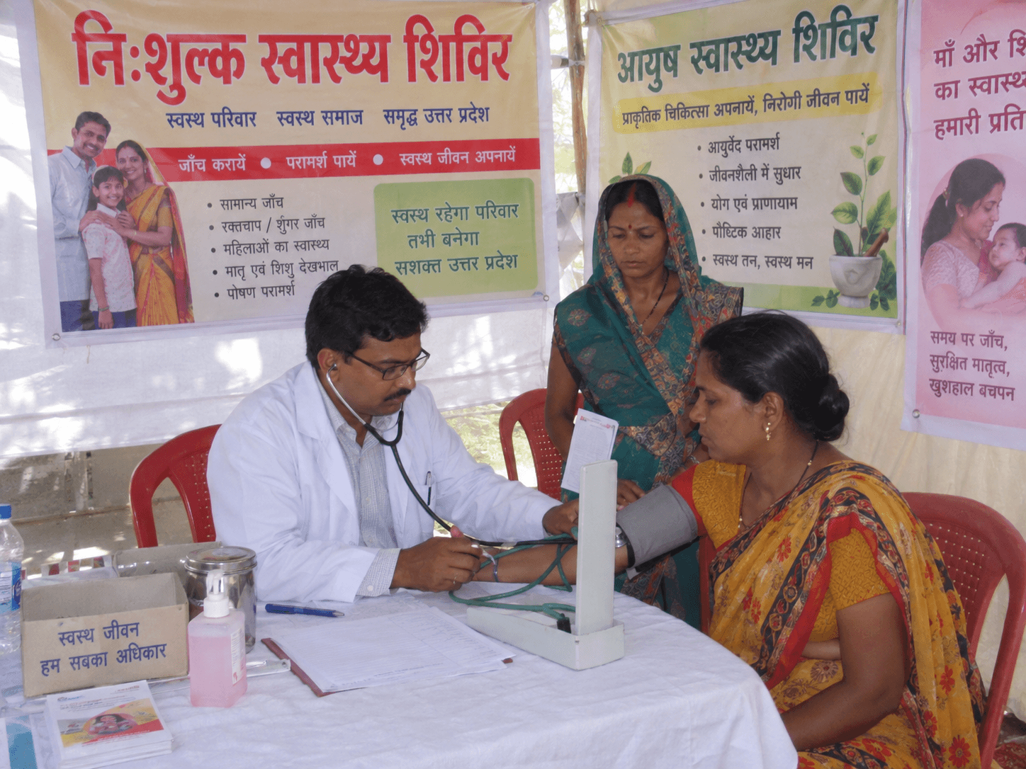 A woman undergoing blood pressure screening during a healthcare camp