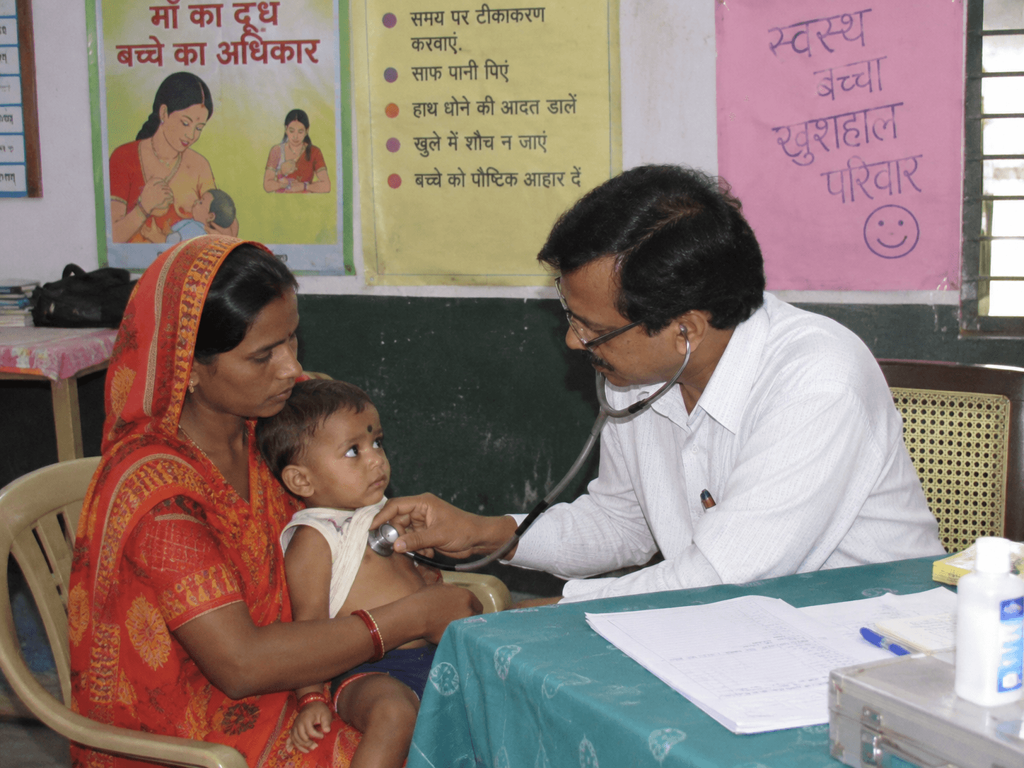 A young child receiving medical examination with a parent during a health camp