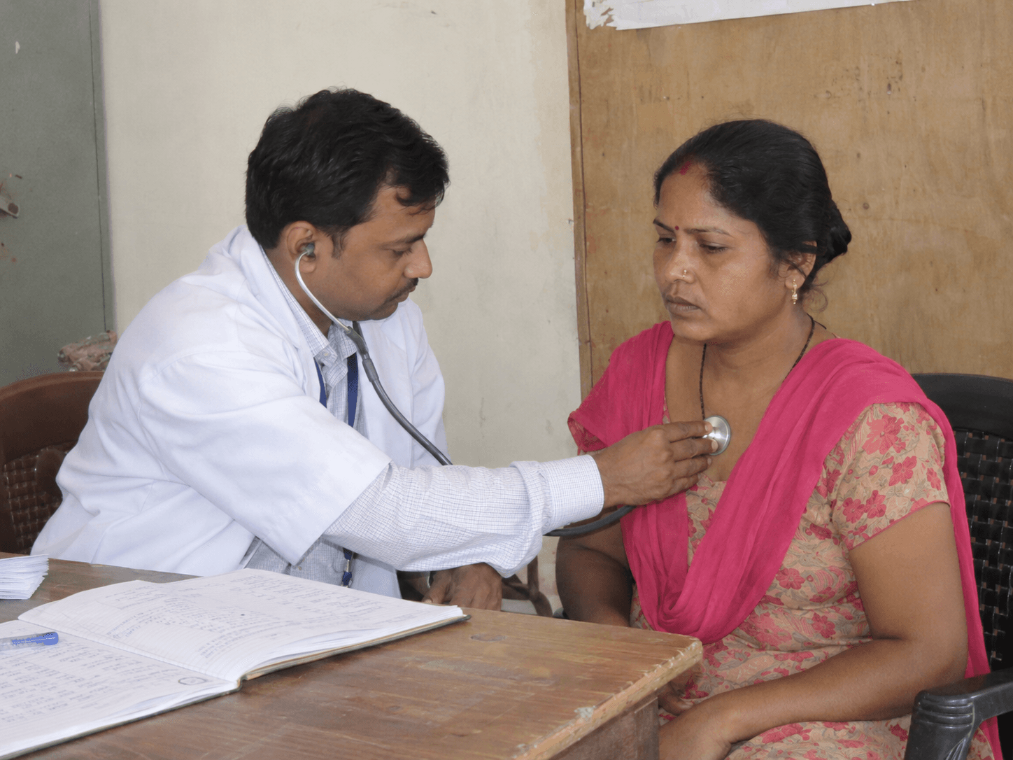A doctor examining a patient during a community healthcare programme